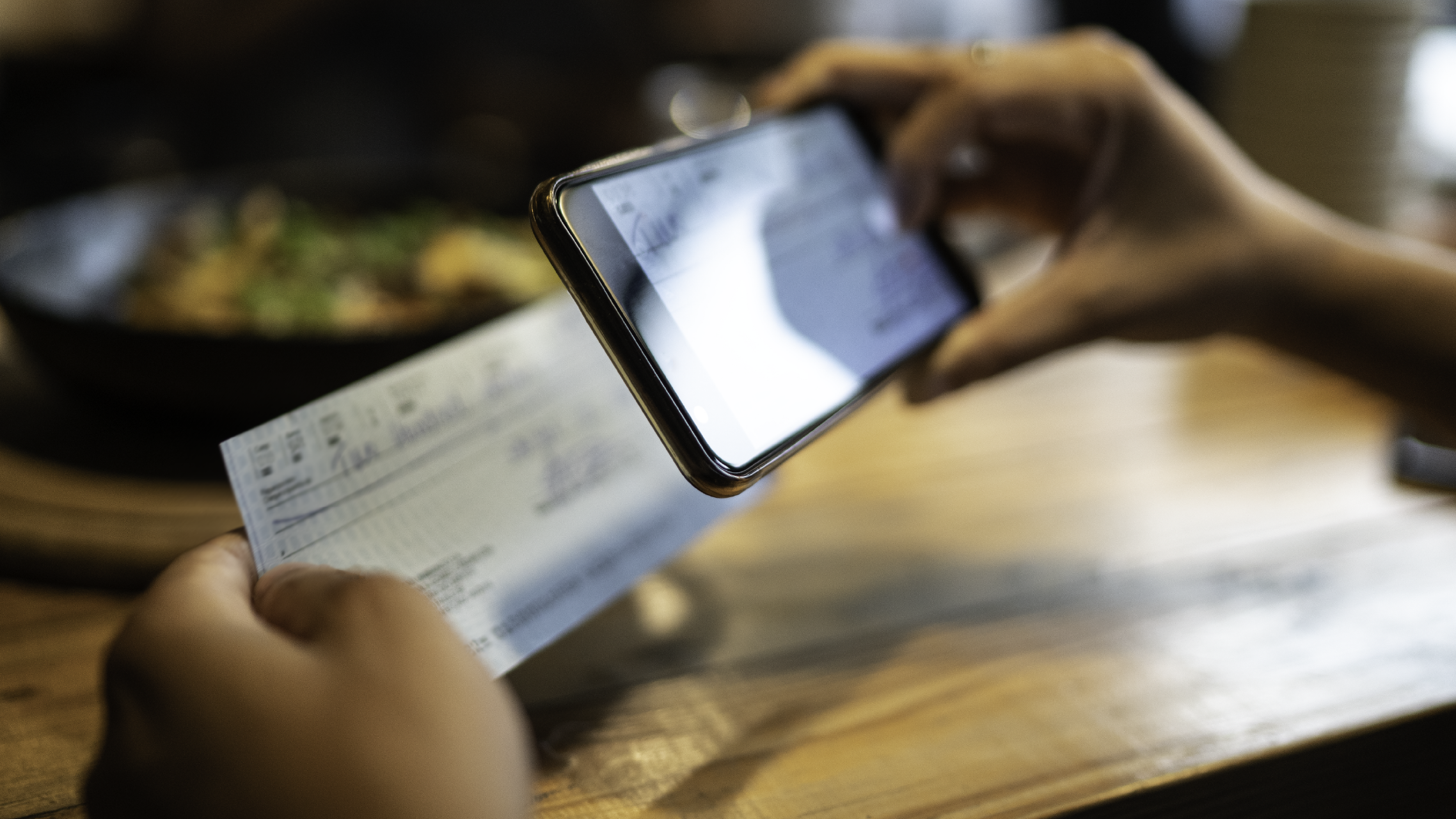 Une personne déposant un chèque de remboursement de dépenses par voie électronique à l'aide d'un appareil mobile