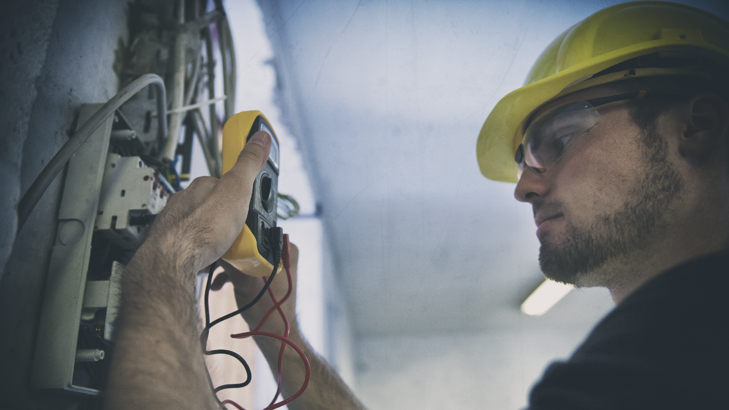 Electrician testing for voltage in fuse box of a construction site