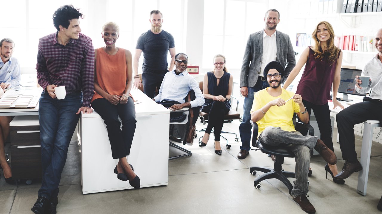A group shot of people in an office showing diversity