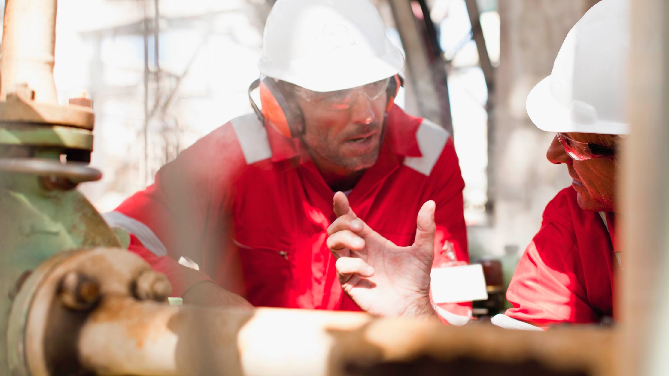 Inspectors examining equipment on site and wearing protective gear