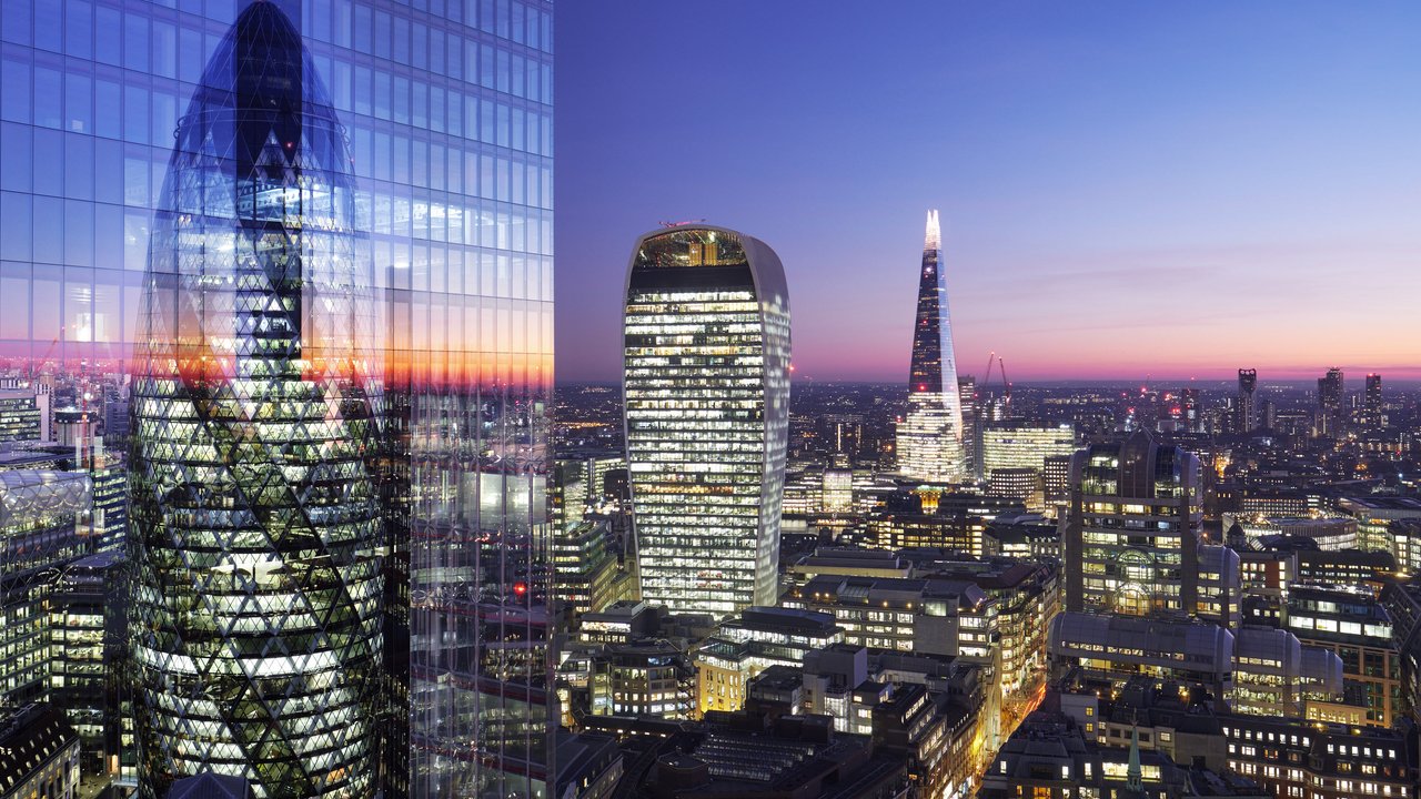 City skyline at dusk featuring the Gherkin, Walkie Talkie, and Shard buildings with a colorful sunset.
