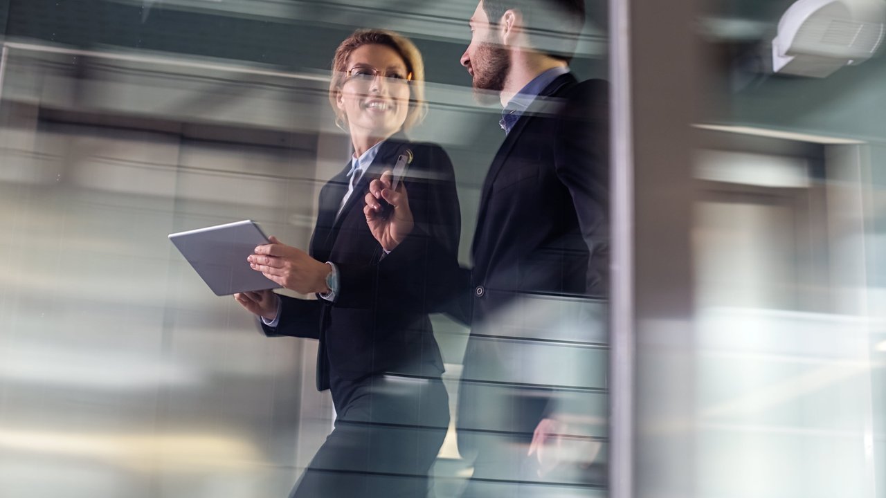 A woman and man walking through an office