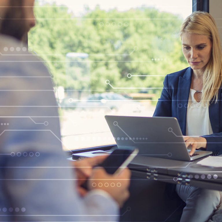 The role of business computer insurance in an evolving digital world Woman using a laptop on a train
