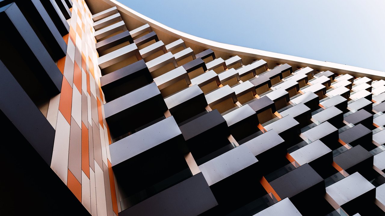 A modern building with multiple coloured balconies and panelling