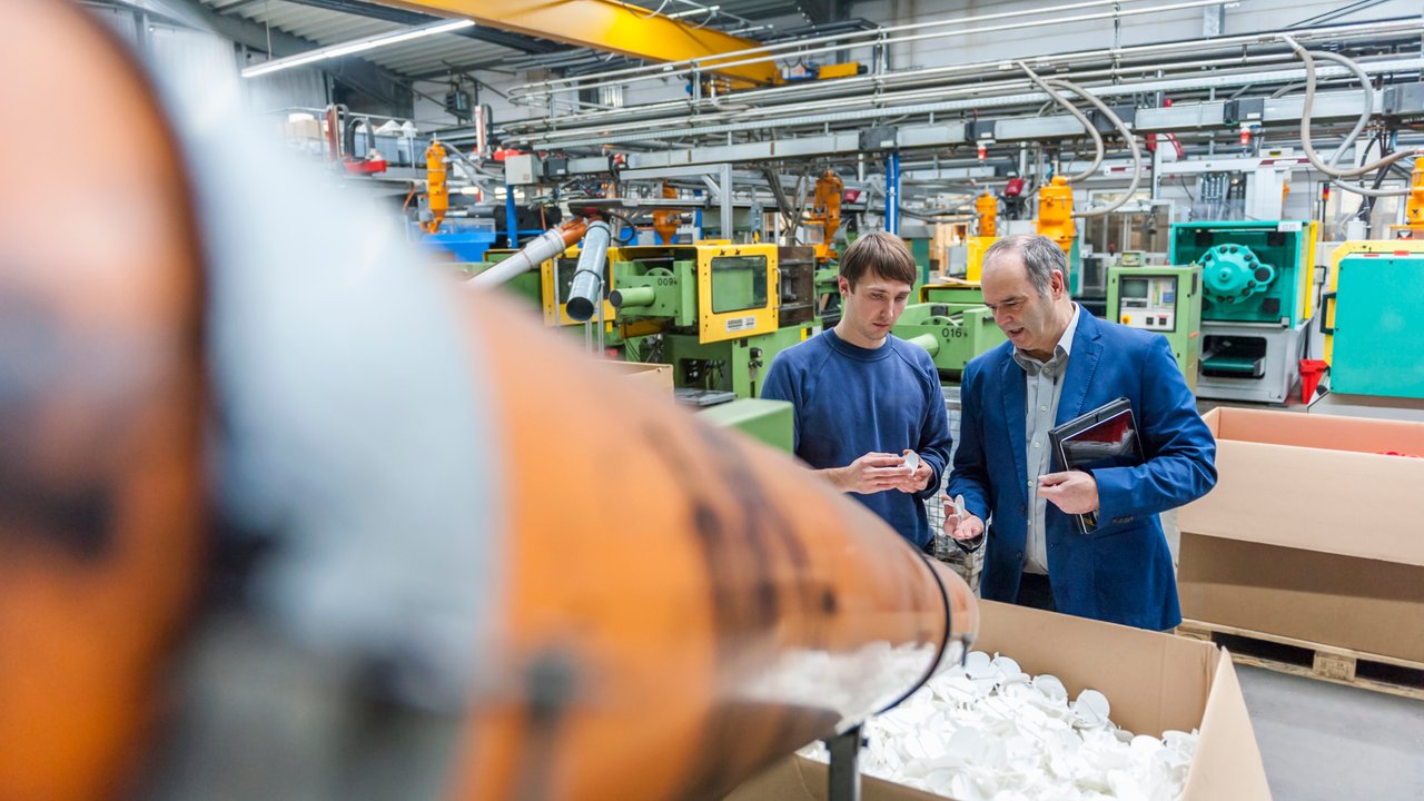 Two employees in a plastics factory