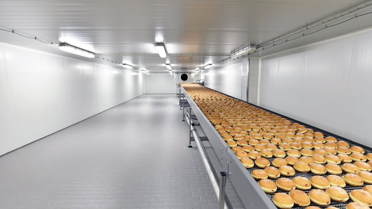 A food processing line within a factory, featuring doughnuts