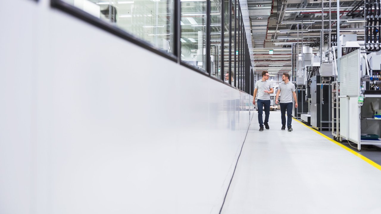 Two men walking through a factory
