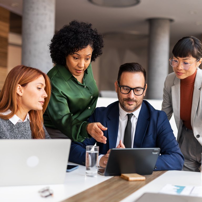 A group of employees examining a laptop screen