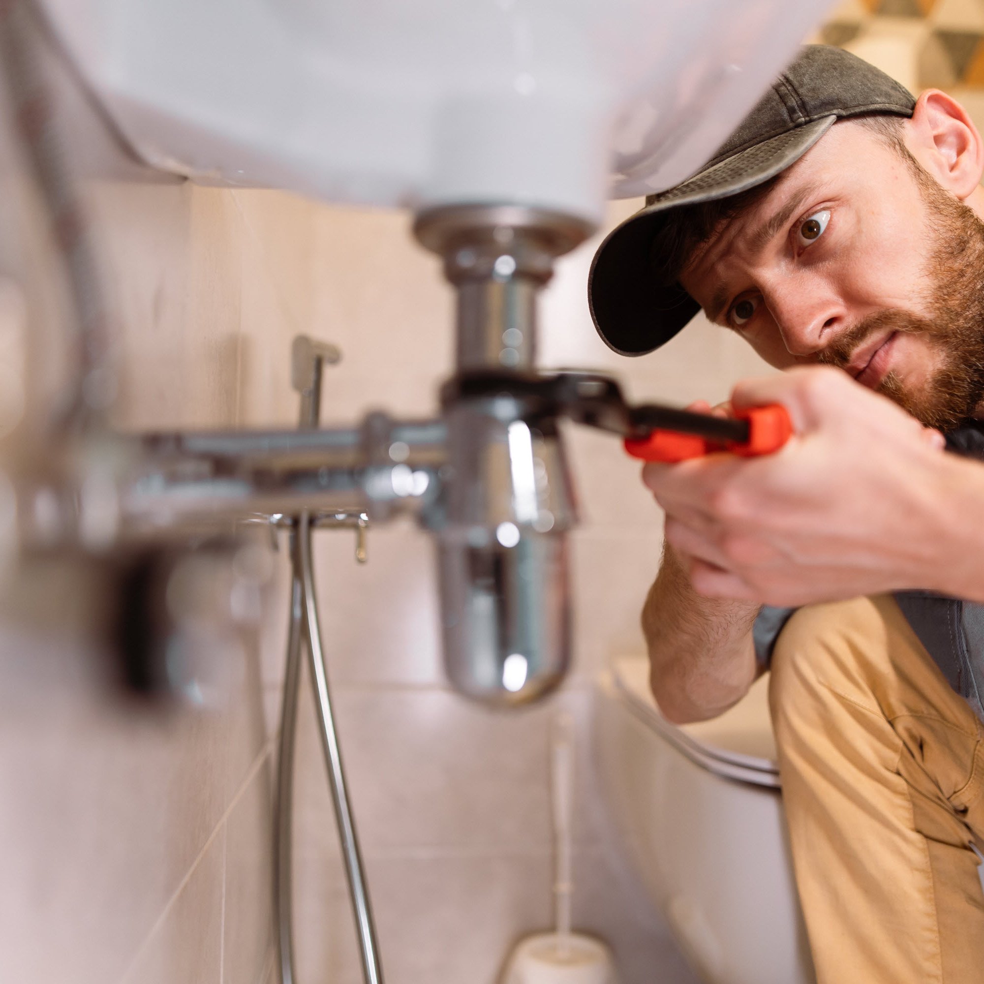 HSB CyberPro in action A plumber fixing a pipe beneath a sink