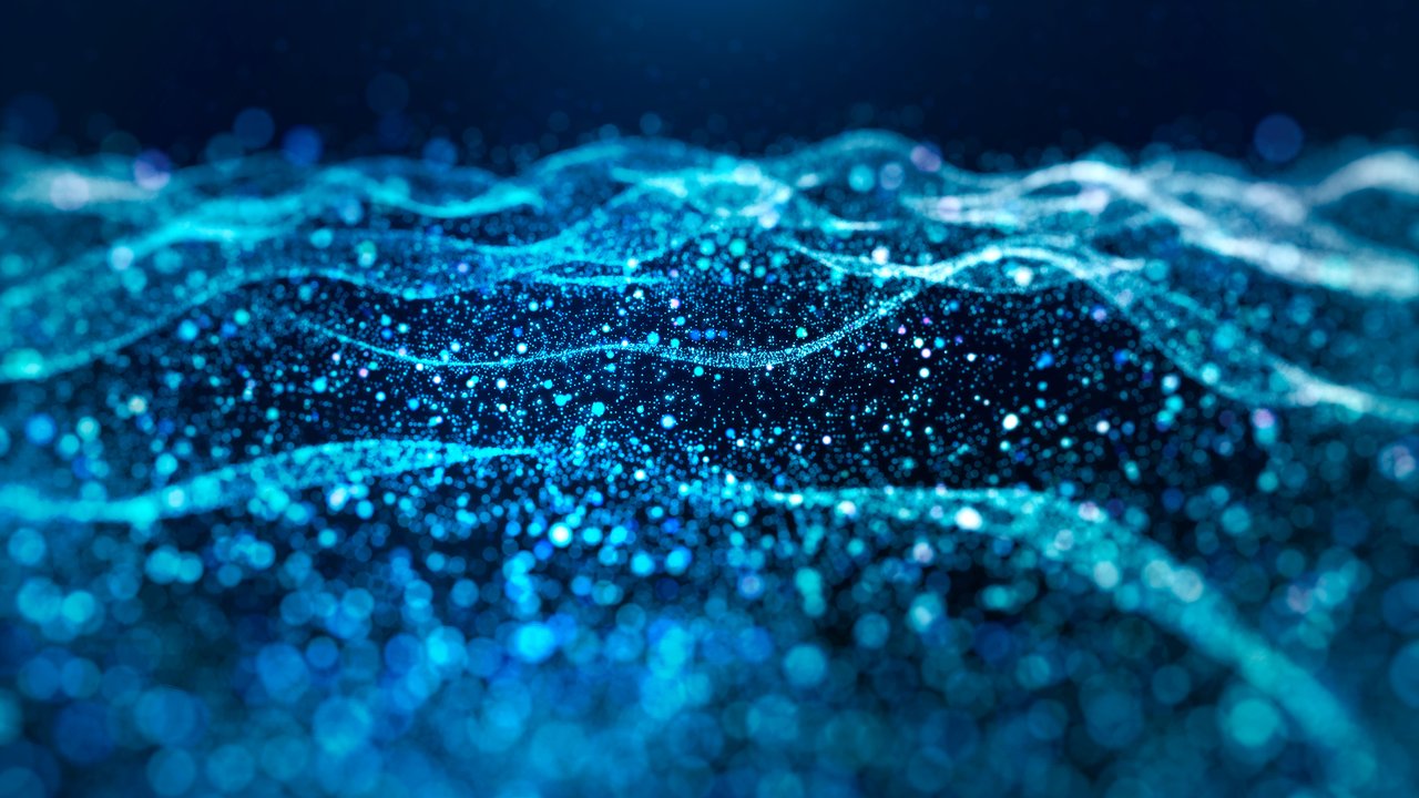 A mesmerizing abstract scene features shimmering waves of blue light and sparkling particles. The background is dark, enhancing the vibrant turquoise and azure hues. The flowing lines create a sense of movement, while the scattered dots add depth and texture, evoking a serene underwater or cosmic atmosphere.