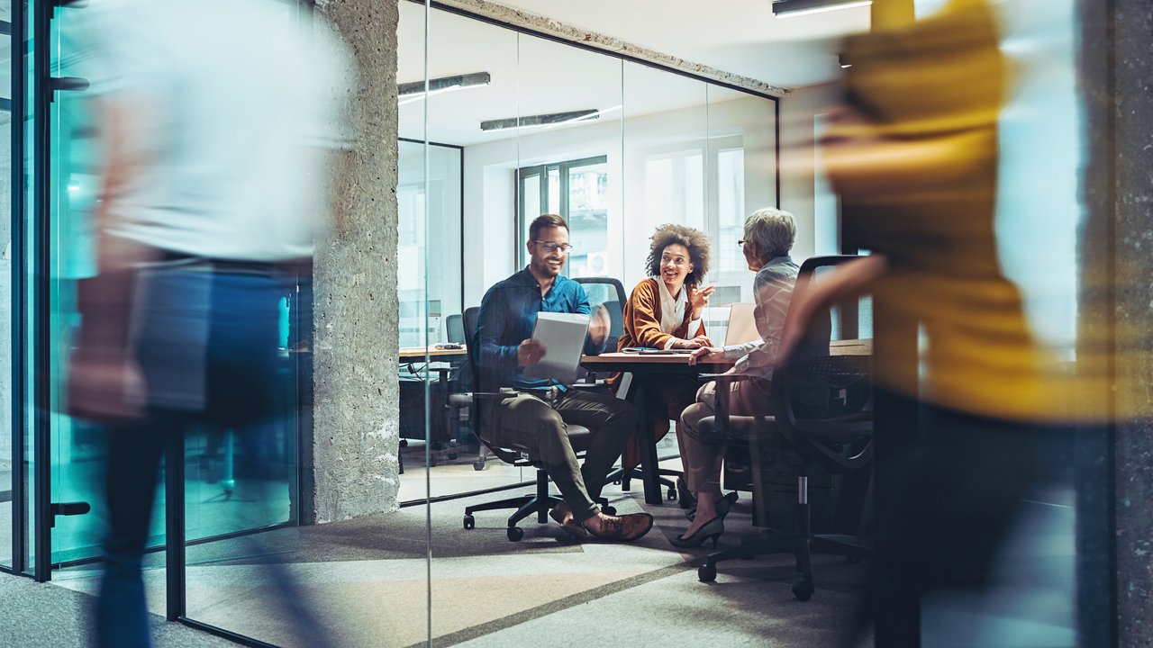 A Group of businesspeople sitting in meeting and listening to female colleague