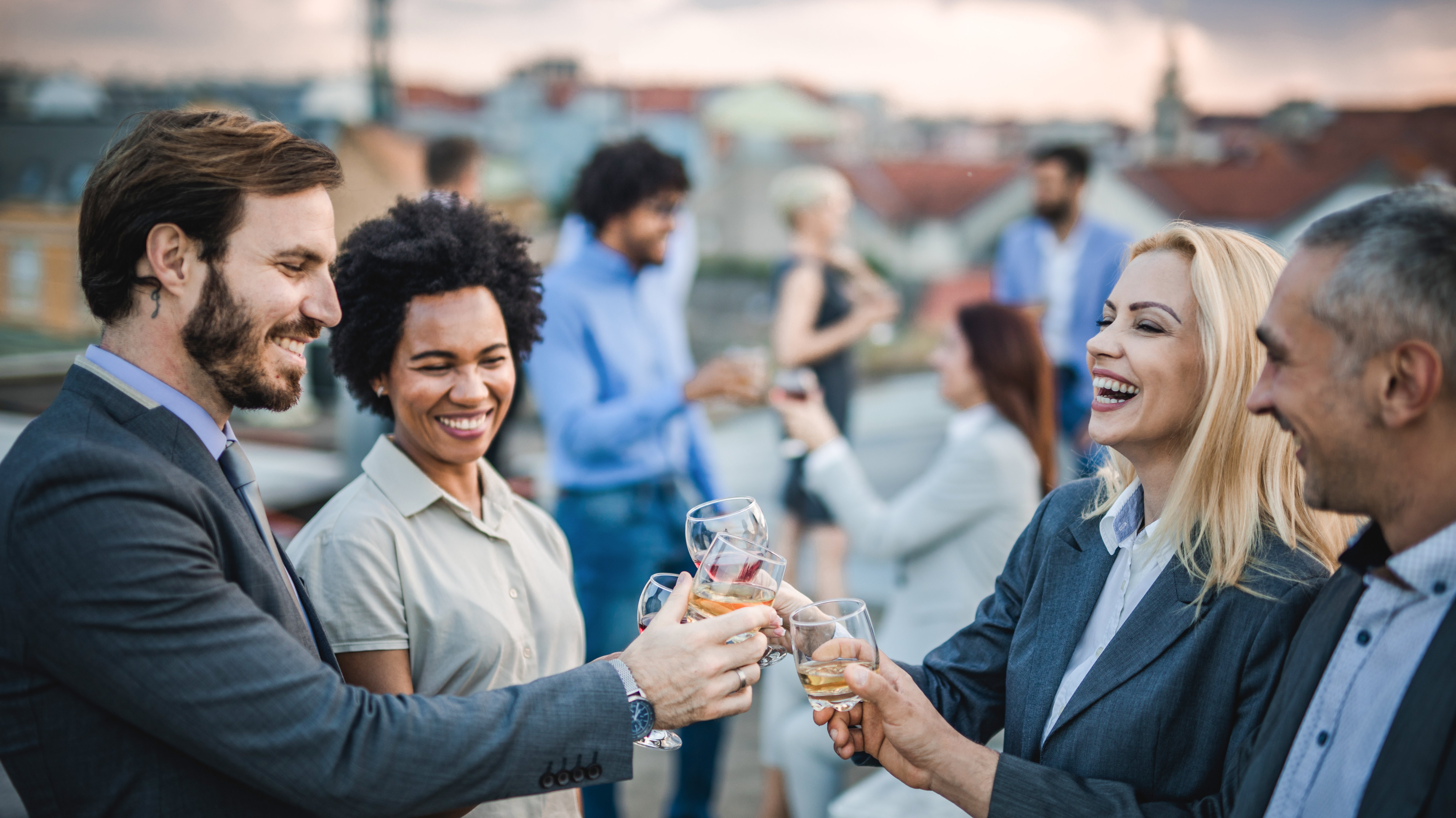Kick of March Madness with HSB Group of happy business people having fun while toasting with alcohol at the outdoor party.