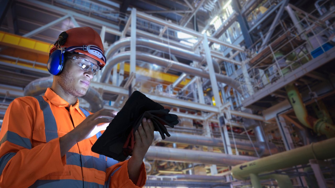 Inspector holding computer tablet in industrial space