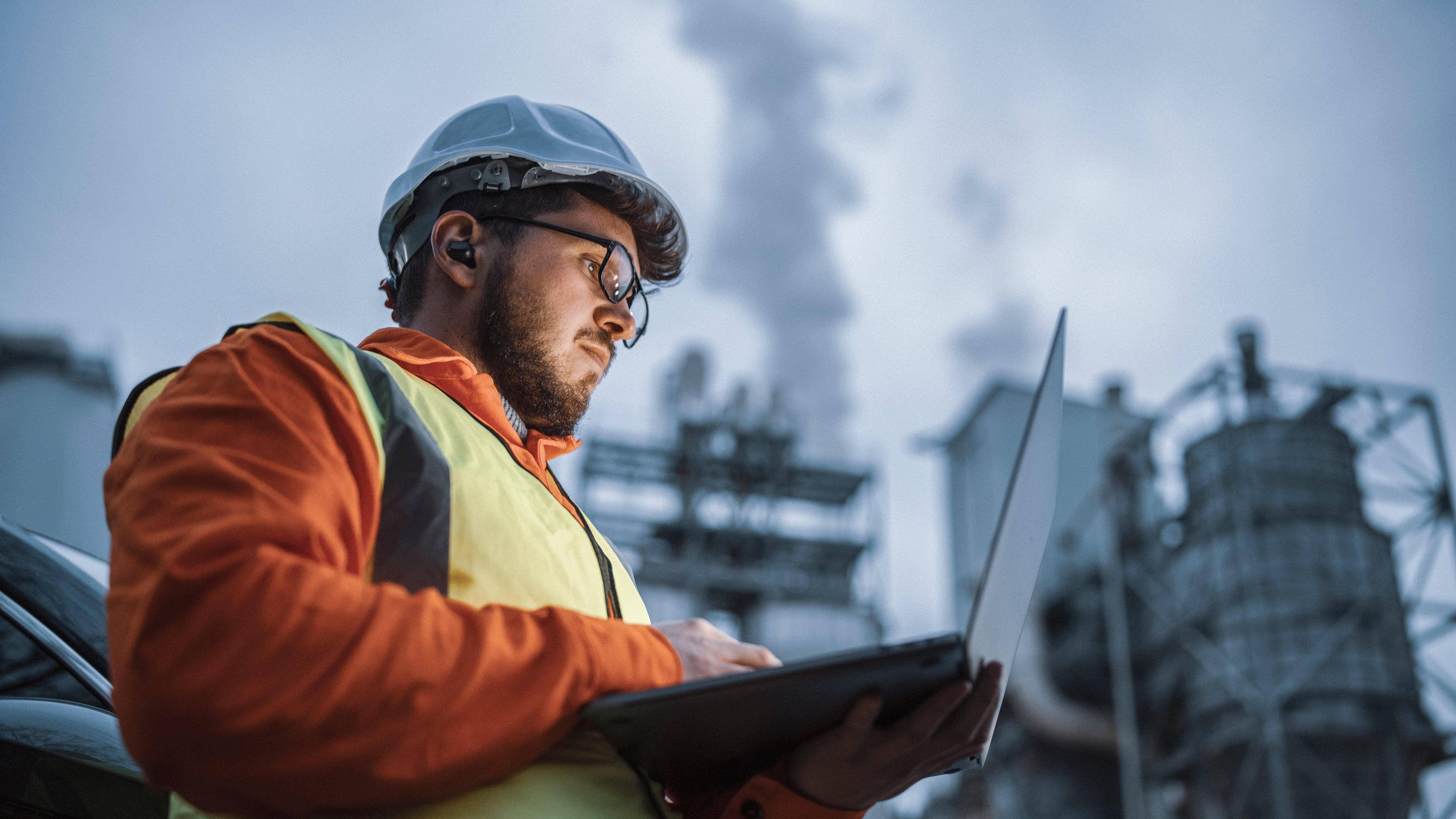 Male engineer wearing hard hat and using tablet