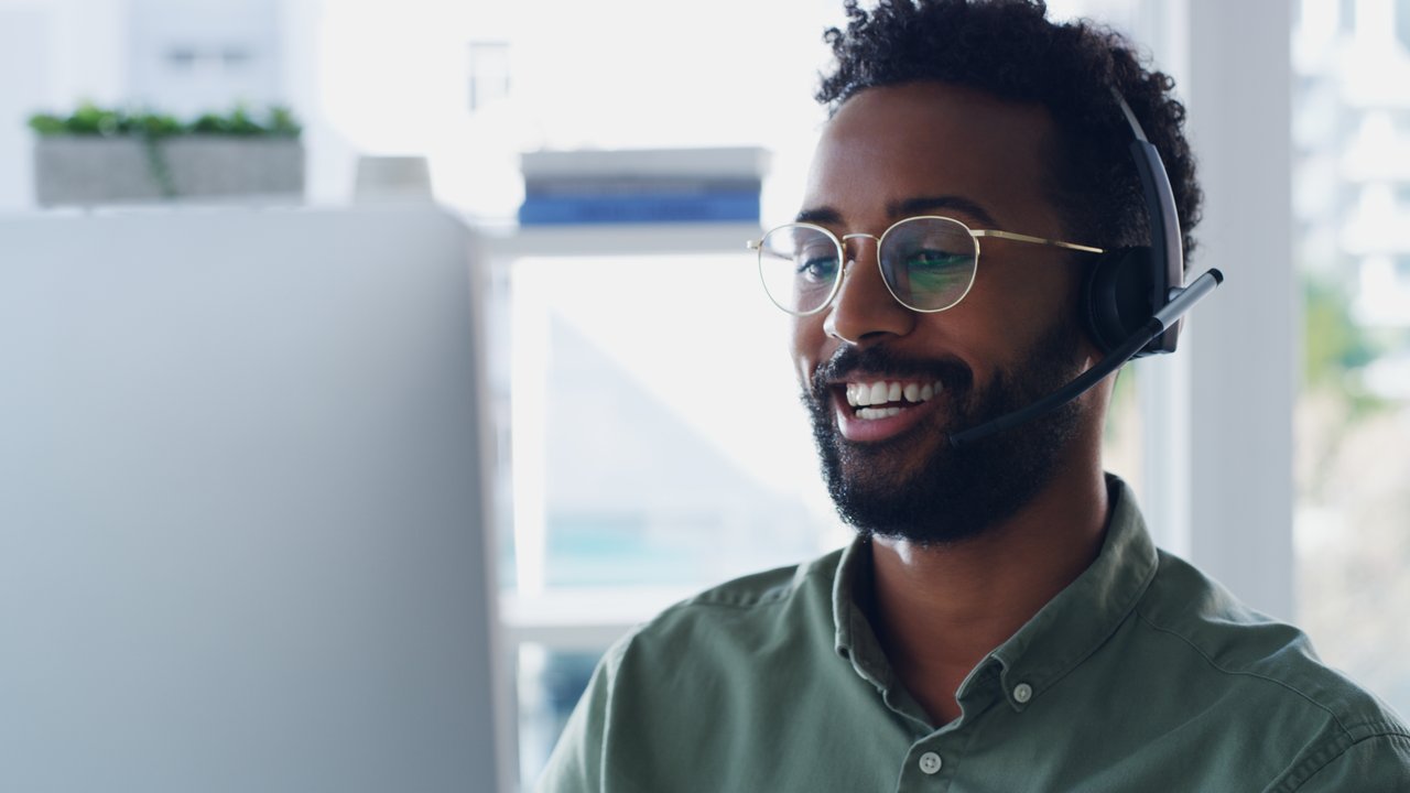 Man with telephone headset working on a computer