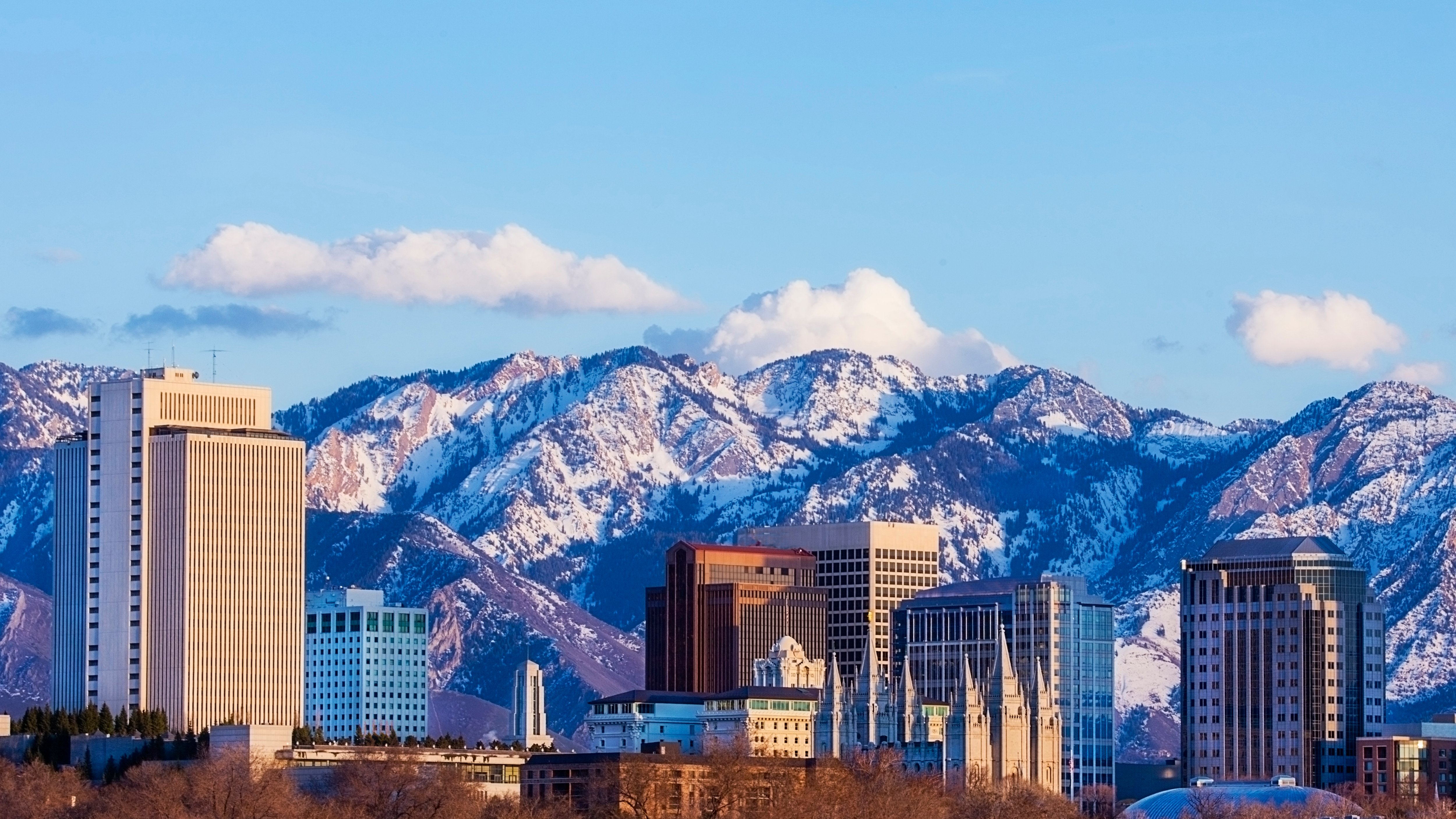 modern hi rise buildings in front of mountain range and blue sky