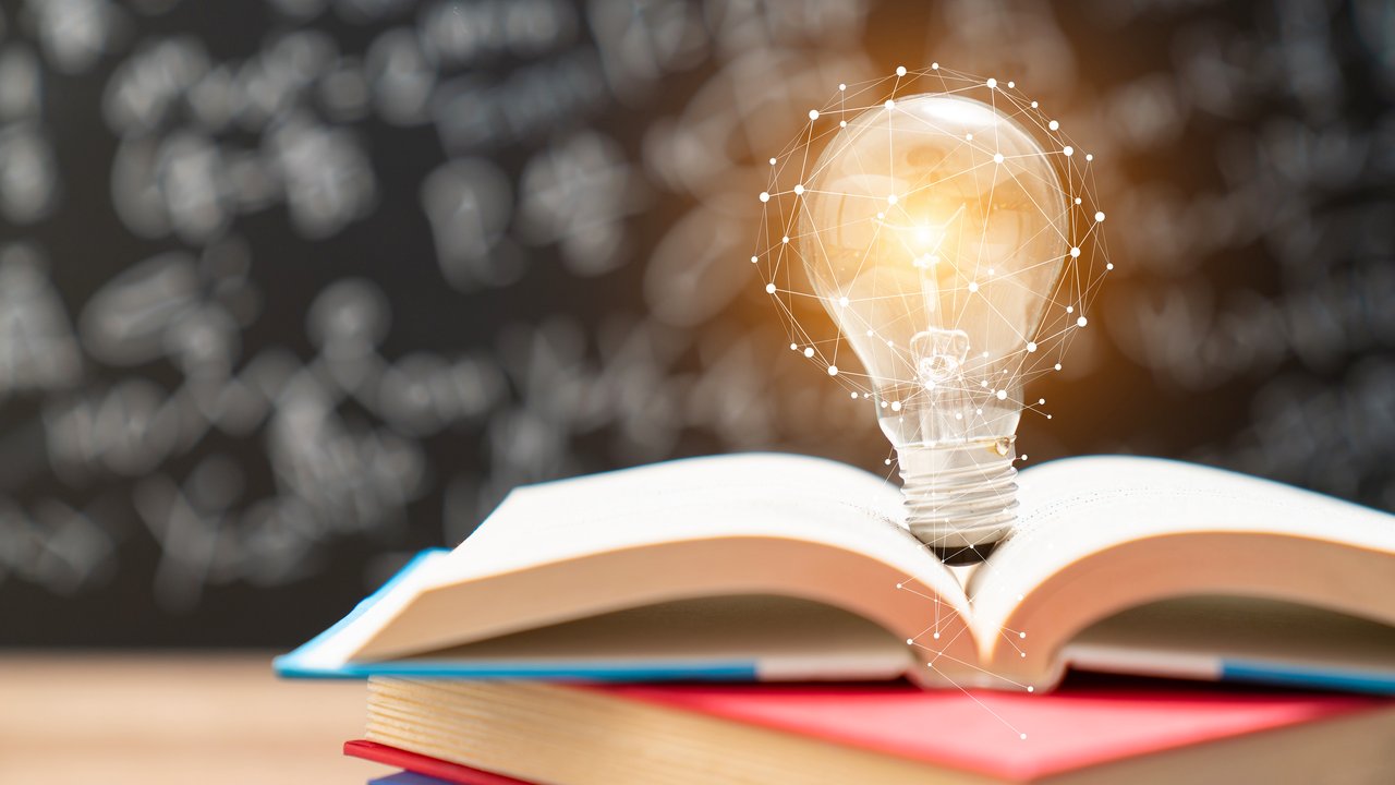 Lightbulb on top of open books that represent ideas