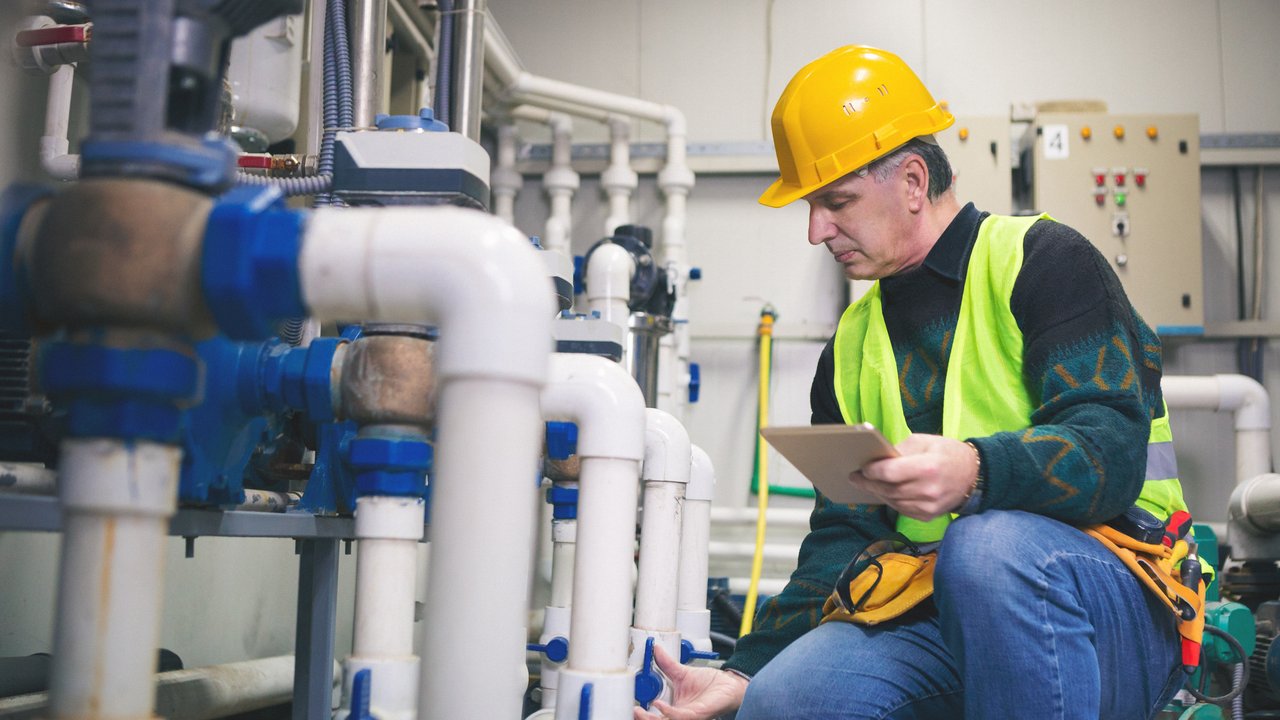 Senior man in a boiler room working.