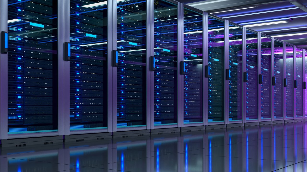 A row of server racks with blue lights in a data center, reflecting on a polished floor.
