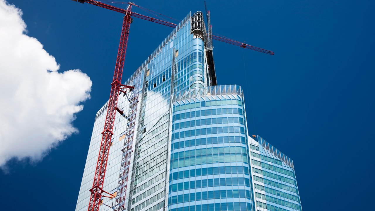 high rise commercial office building in construction stage with crane
