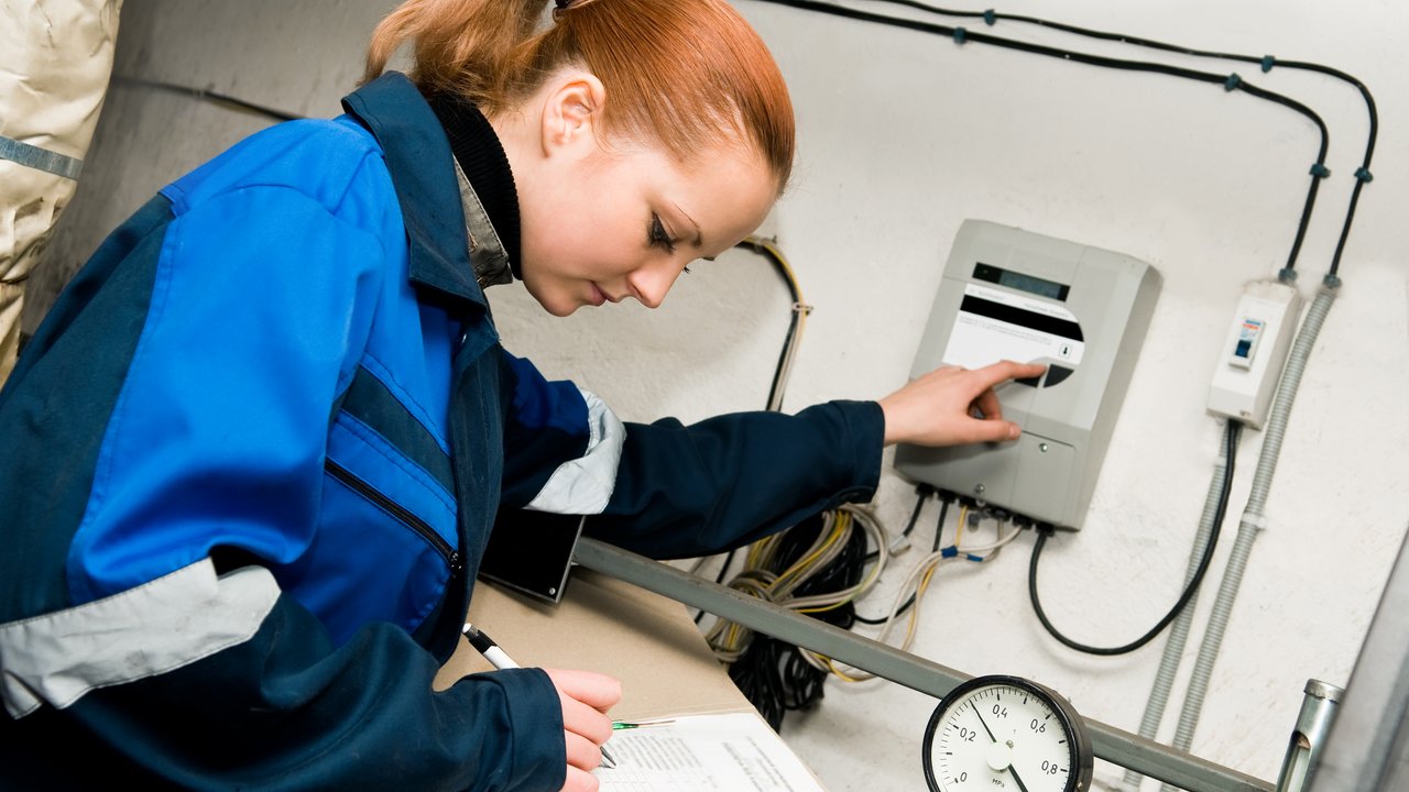 woman engineer checking technical data of heating system equipment in a boiler room