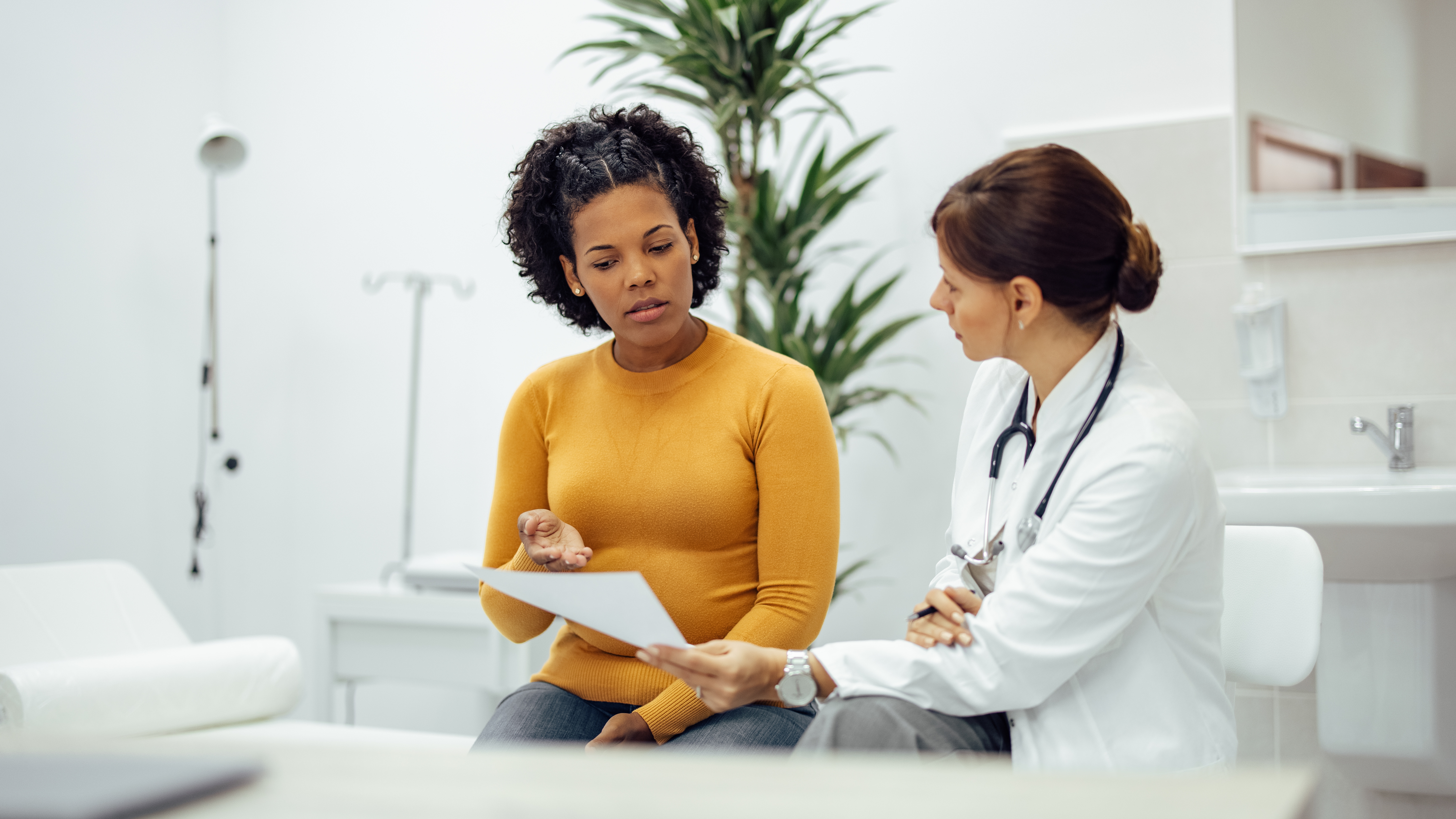 Female patient and doctor discussing test results in medical office.