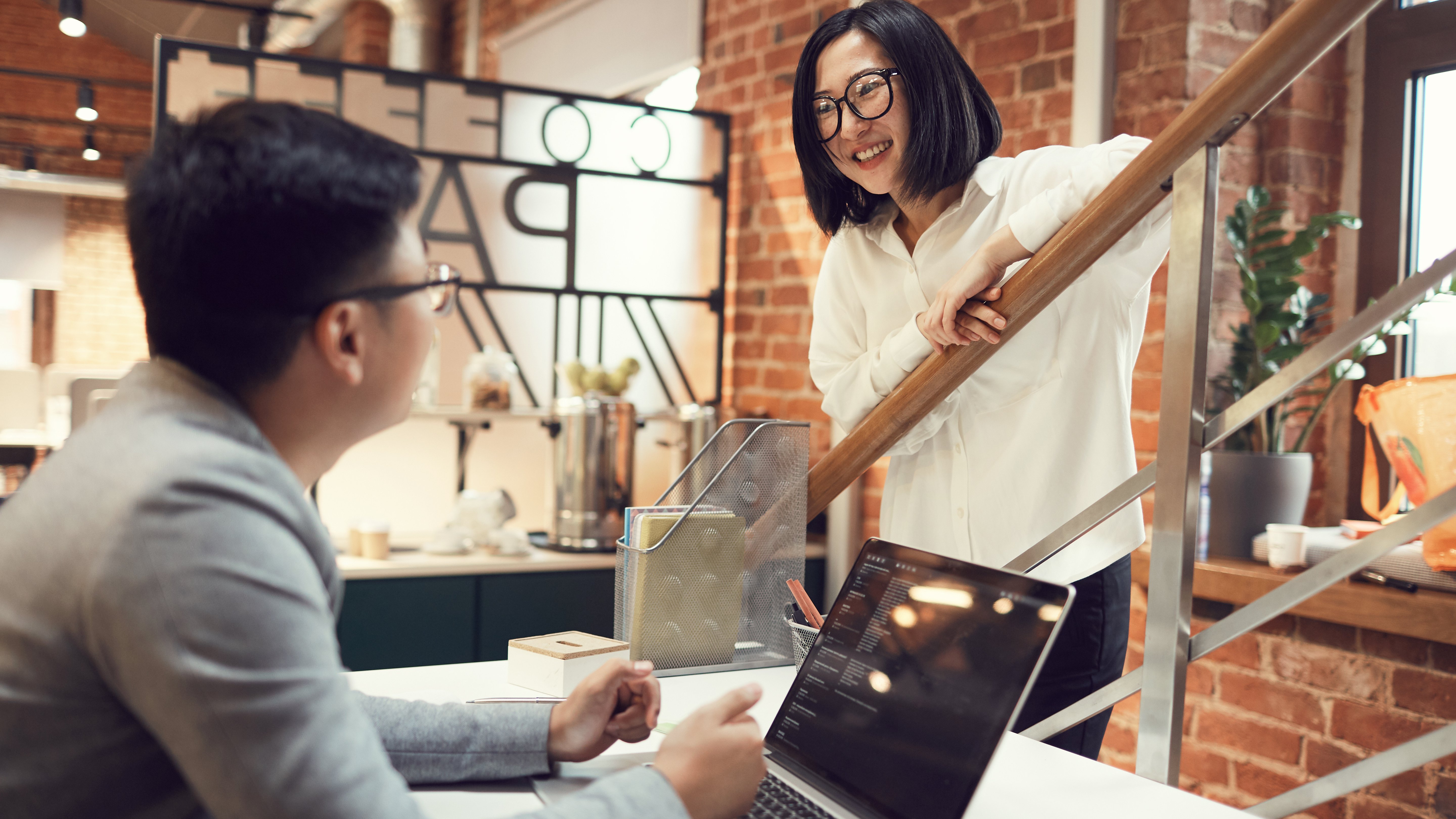 Businesswoman talking  with a colleague while working in modern office.