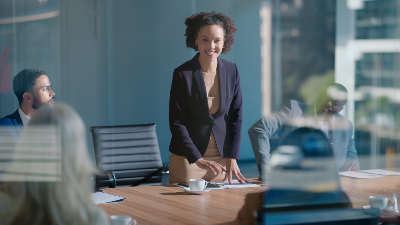 Business professionals  walking across an enclosed city glass bridge 