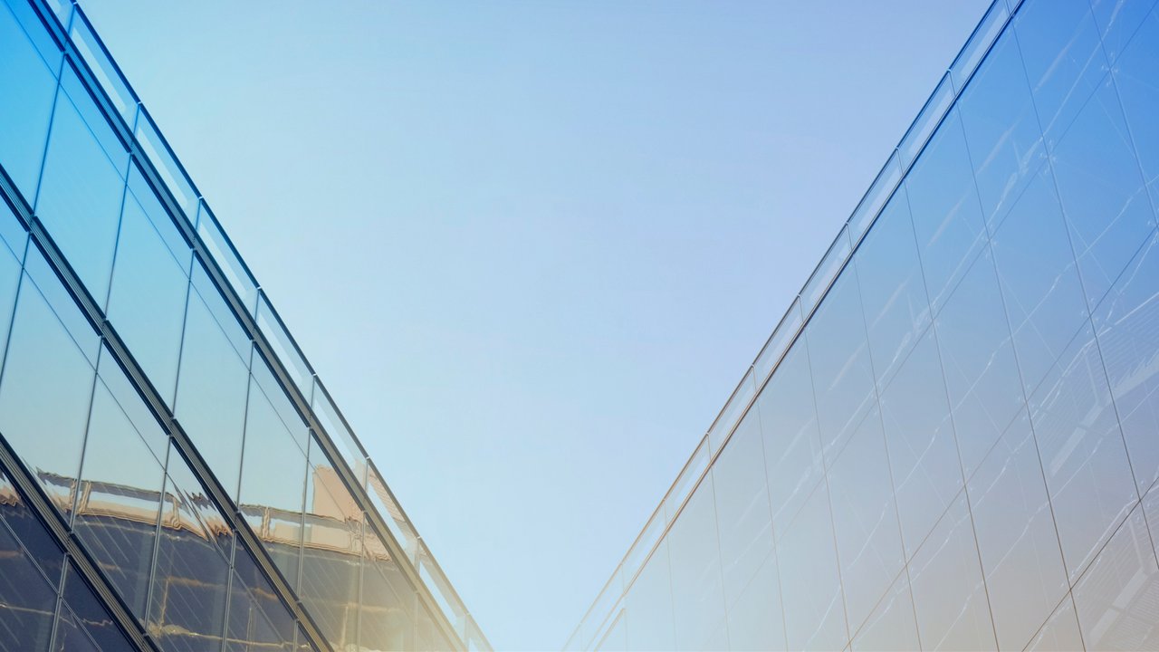 Modern glass building with bright light in center.