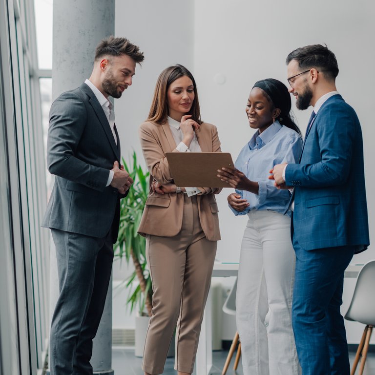 Business Meeting in Modern Office Space Two professionals discussing in a modern office setting with large windows and bright lighting.