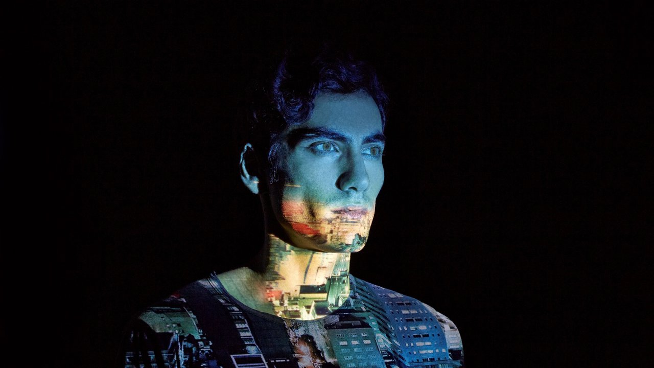 Man face displaying the reflection of a video playing