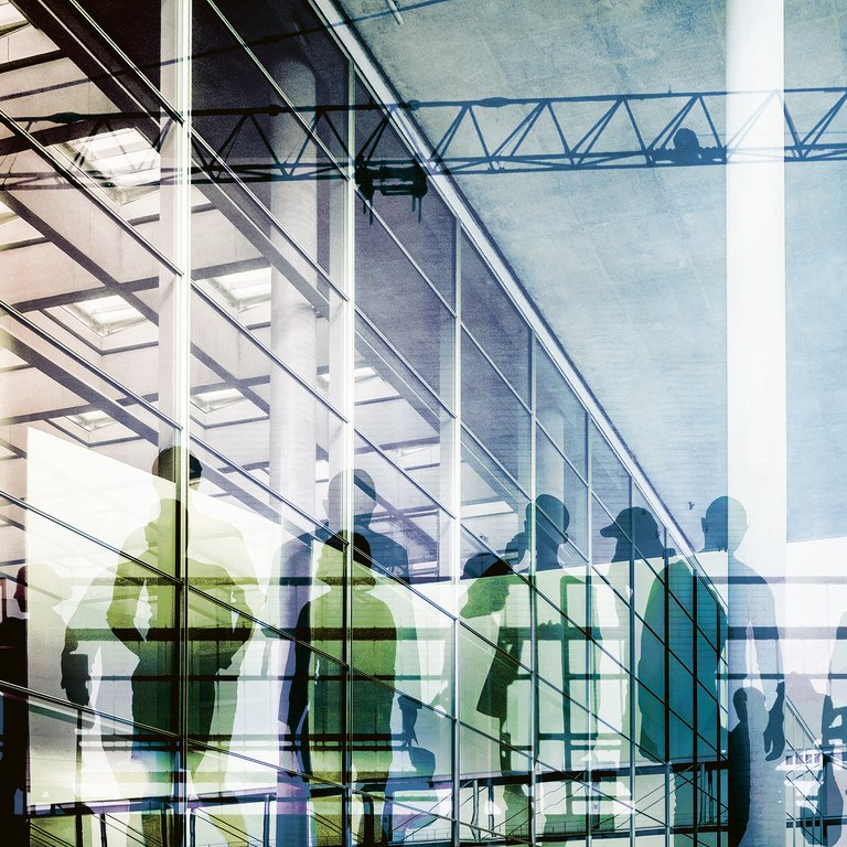 Silhouettes in a Modern Architectural Space Silhouettes of people walking near glass walls in a modern architectural space with visible structural elements.