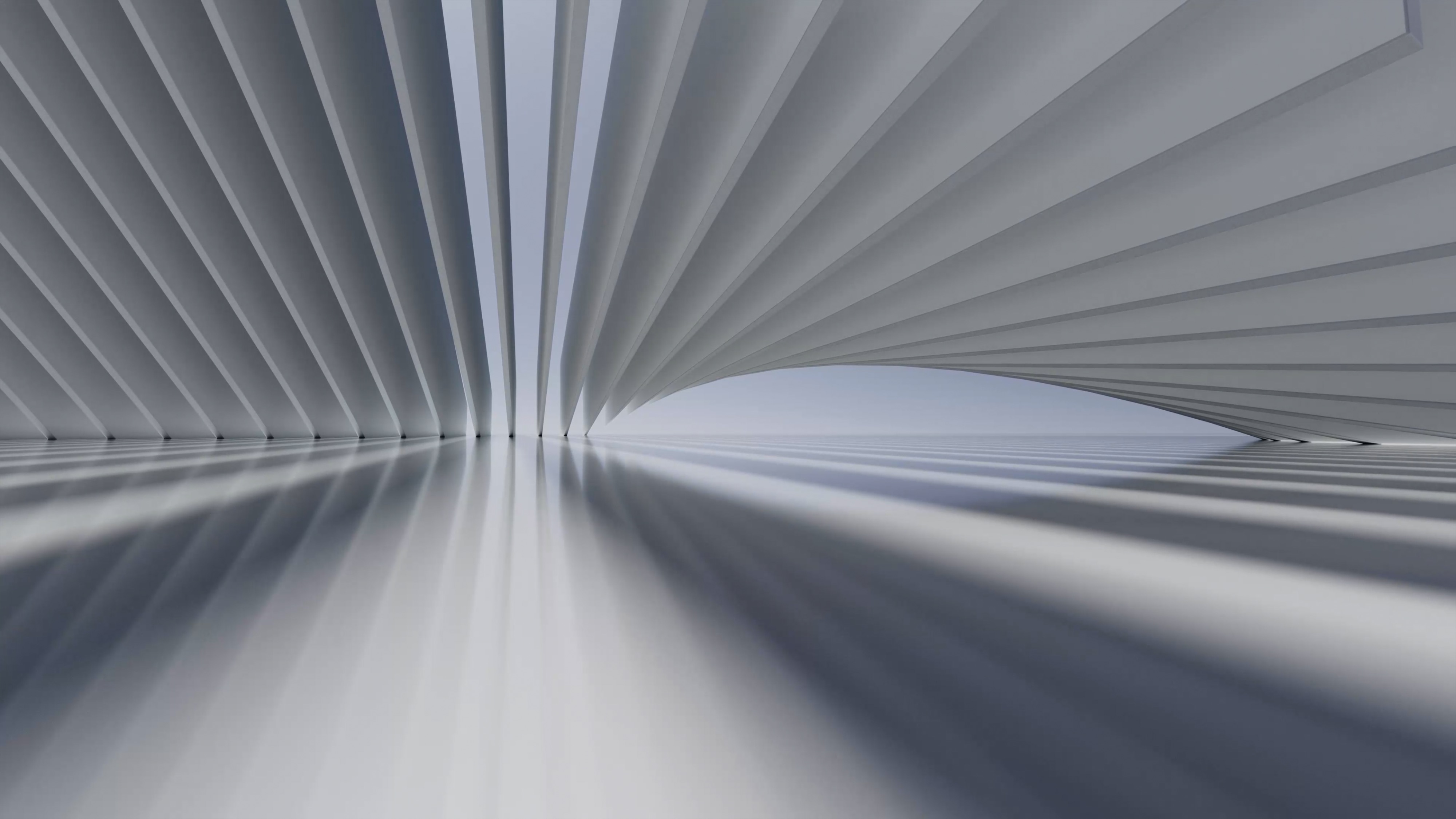 A modern architectural structure with curved, layered surfaces and reflections on a smooth floor.