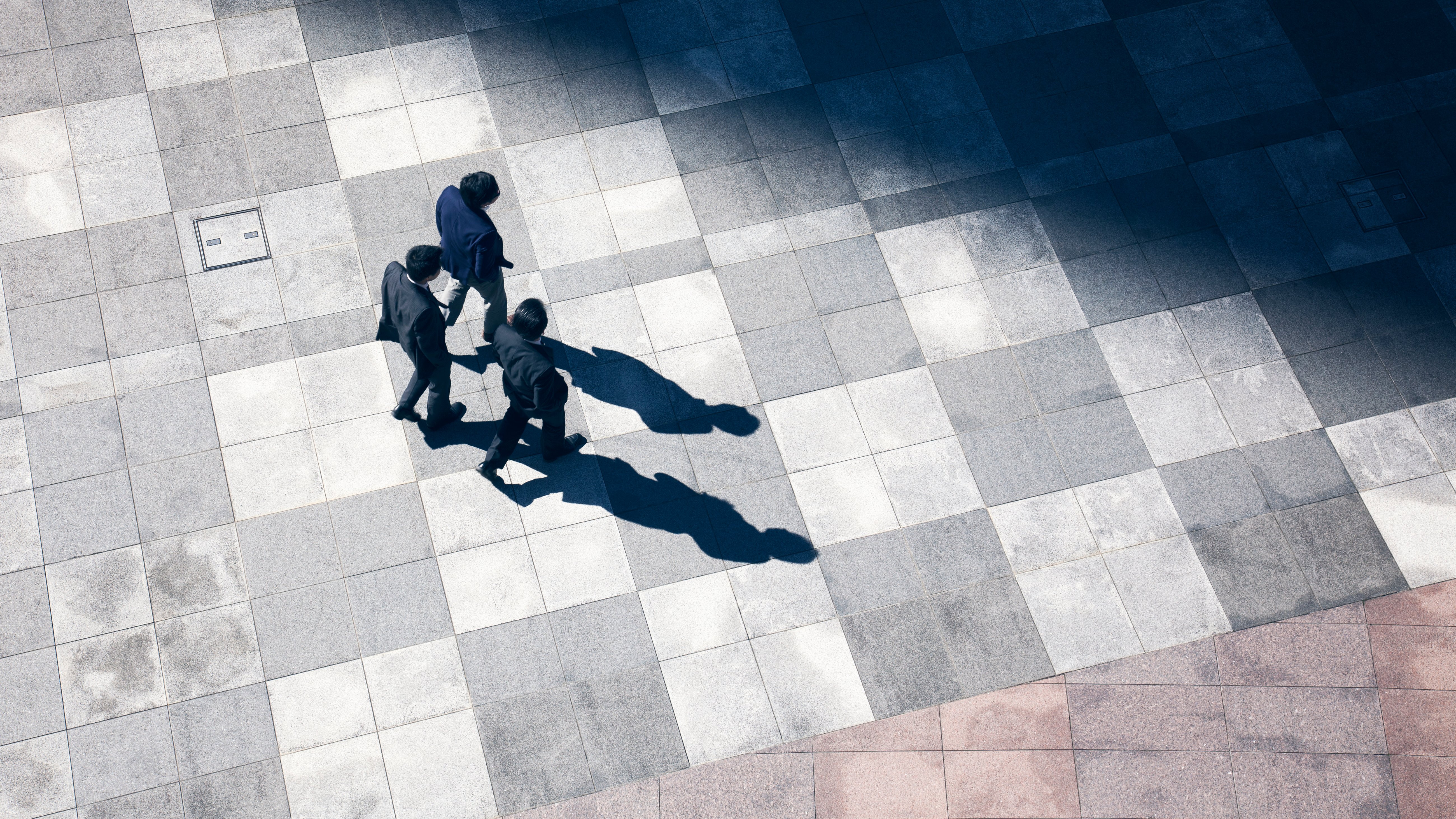 Business men walk in the business district together. A bird's-eye view.