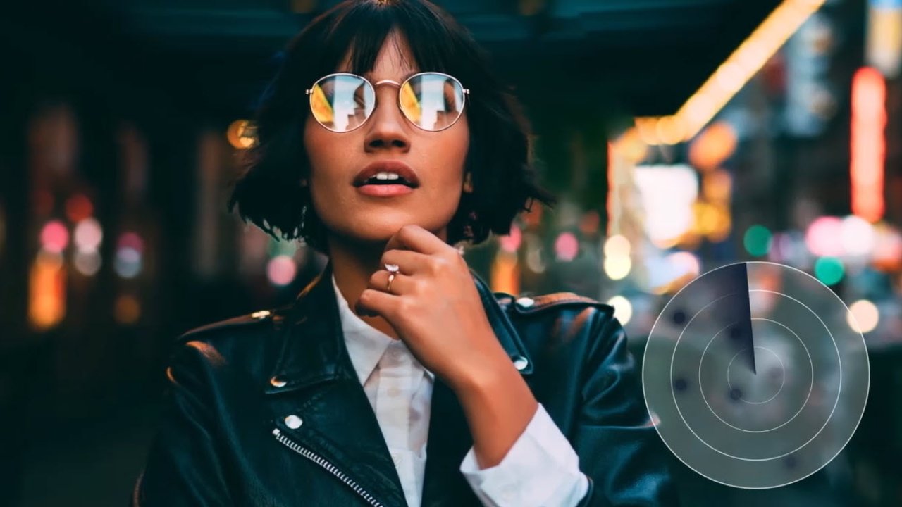 Young trendy dressed hipster in eyewear with night city light reflection fascinated with beautiful illumination, gorgeous woman in leather jacket wondering while standing on urban background at evening