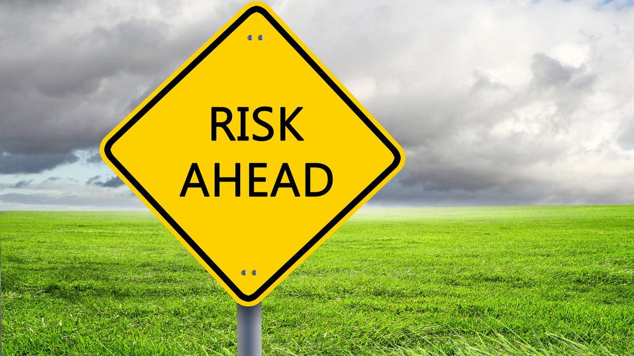 yellow road sign as a warning of risk ahead