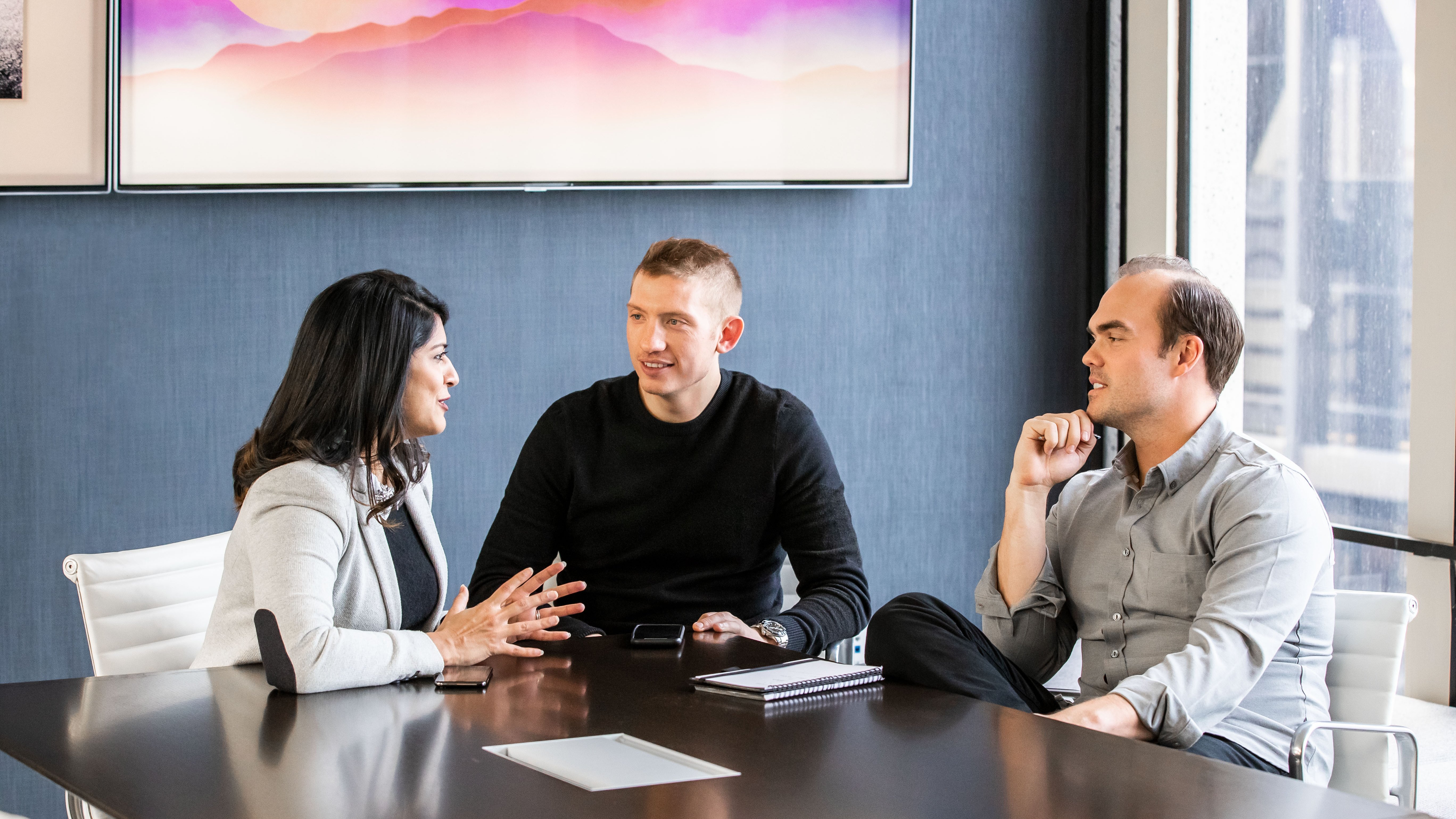 Team sitting around a desk working together.
