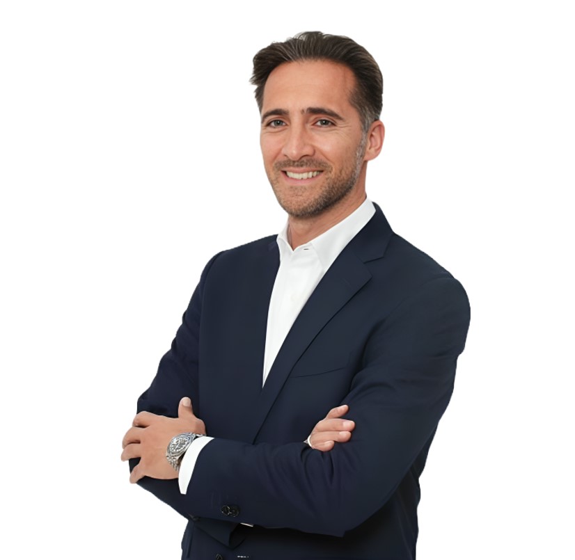 Gianluca Piscopo in a dark suit and white shirt stands with arms crossed against a plain white background.